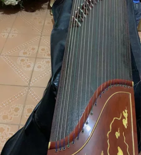 出一把闲置的古筝，明月品牌颜色棕色采用传统...