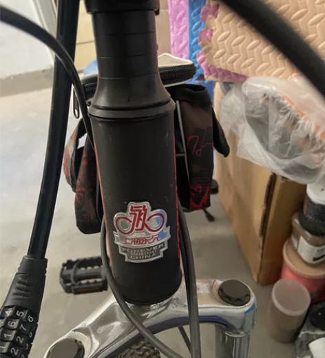 出一辆黑色的自行车，品牌上海永久该自行车为...