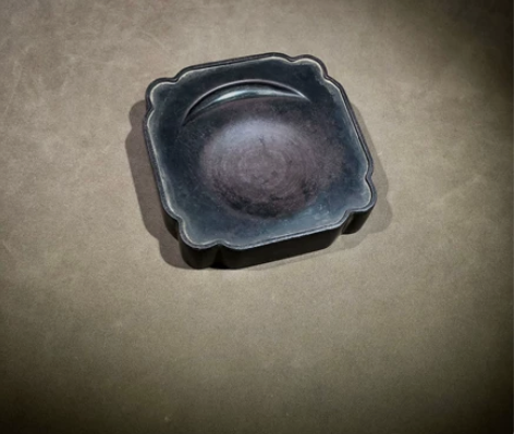 端砚,正方形,墨池作弯月形,砚面周缘有凸起...
