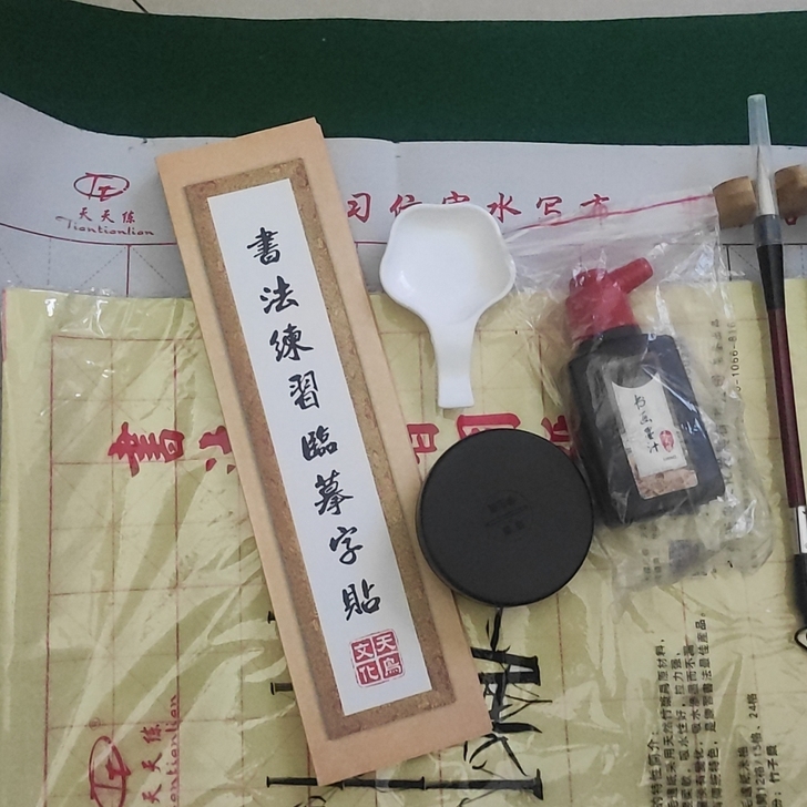软笔书法练习。有水写布，纸，字帖，墨，毛笔...