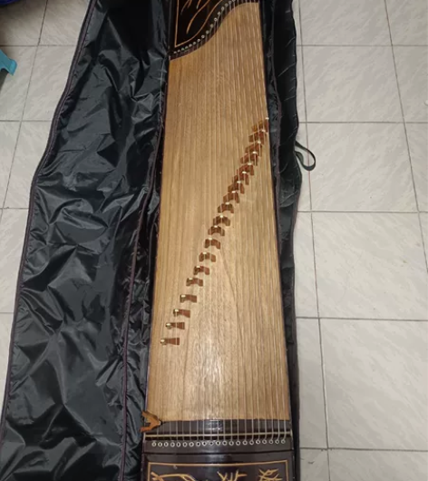 一个旧旧的古筝，用了好些年了，琴包是新的，...