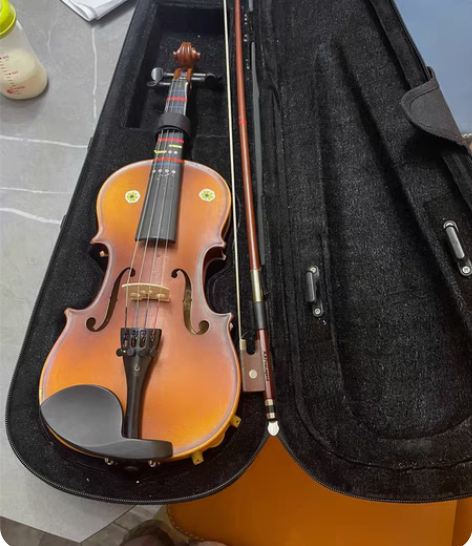 小朋友换新的小提琴了，原来的小提琴是老师推...